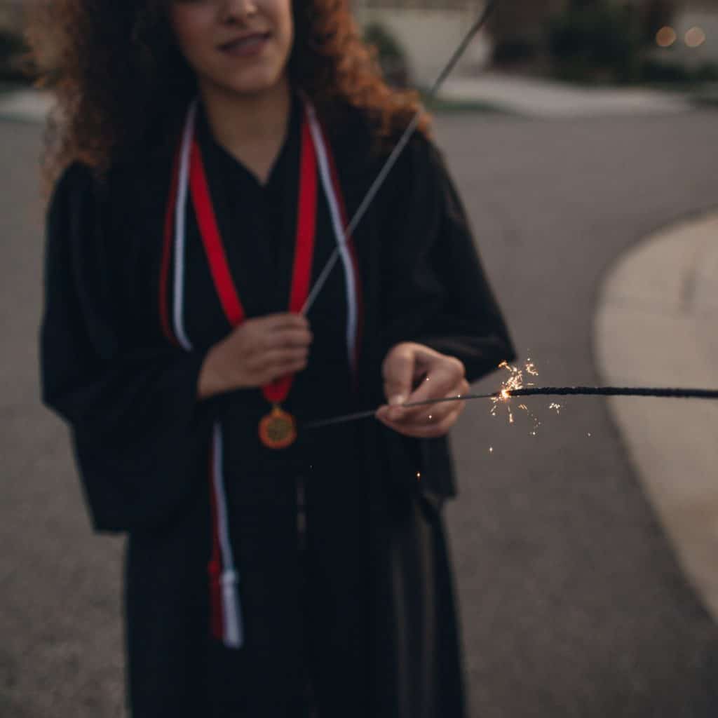 Hppy graduate holding sparklers